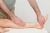 Physiotherapist touching the calf and the foot of a patient