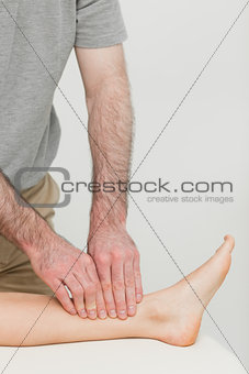 Fingertips massaging a shin bone