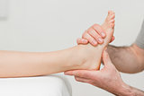 Hands of an osteopath massaging a foot