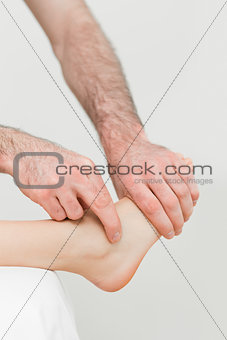 Physiotherapist touching the foot of a patient