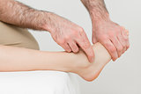Hands of a physiotherapist massaging the foot of a patient
