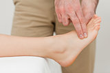 Fingers of a physiotherapist pressing on a foot