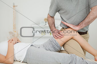 Serious osteopath massaging the knee of a patient