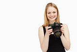 Woman holding a SLR camera while smiling