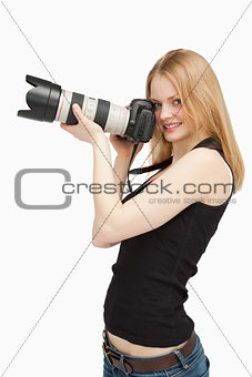 Joyful woman holding a SLR camera