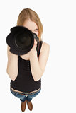 Blonde-haired girl aiming with her SLR camera