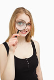 Smiling woman using a magnifying glass