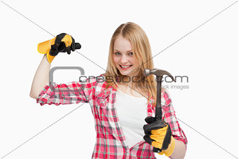 Joyful woman holding a hammer