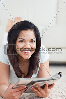 Woman smiling while holding a magazine
