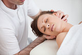 Woman being massaging by the doctor while having the head turn i