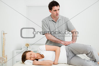 Doctor pressing his hands on the hip of his patient