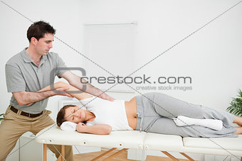 Chiropractor stretching the arm of his patient while holding it