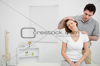 Doctor examining the neck of his patient while stretching it