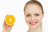Close up of a cheerful woman presenting an orange