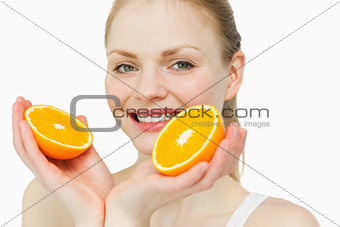 Close up of a cheerful woman holding oranges
