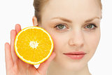 Close up of a woman presenting an orange