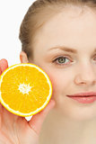 Close up of a blonde-haired girl presenting an orange