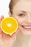 Close up of a smiling woman holding an orange