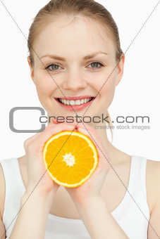 Smiling woman holding an orange in her hands
