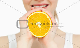 Close up of a woman holding an orange