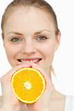 Close up of a woman squeezing an orange between her hands