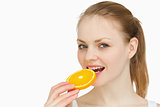 Woman placing an orange slice in her mouth