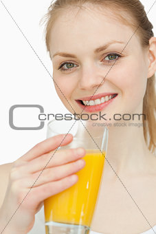 Cheerful woman holding a glass of orange juice