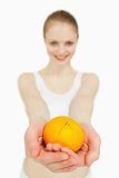 Close up of a woman presenting a tangerine