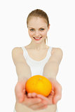 Smiling woman presenting a tangerine