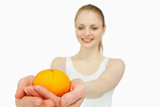 Cheerful woman presenting a tangerine