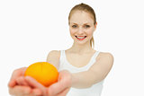 Joyful woman presenting a tangerine