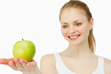 Woman smiling while presenting an apple