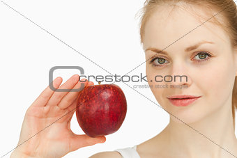 Young blonde-haired woman presenting an apple