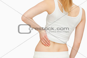 Woman standing while massaging her back