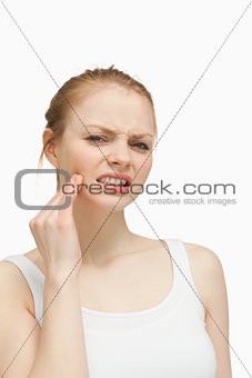 Young woman massaging her jaw
