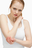 Blonde woman touching her elbow