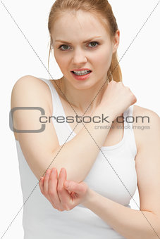 Blonde woman touching her painful elbow