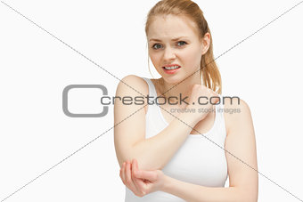 Fair-haired woman touching her elbow
