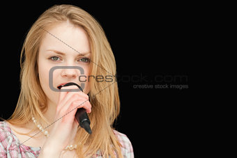 Young blonde-haired woman singing