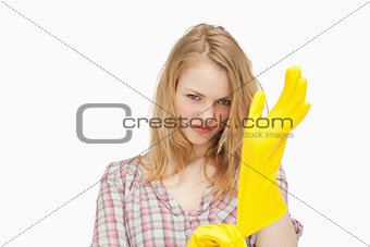 Woman frowning while putting cleaning gloves