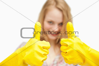 Woman thumbs up while wearing cleaning gloves