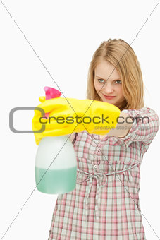 Young woman smiling while holding a spray bottle