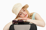 Woman asleep while leaning on a suitcase