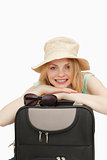 Smiling woman leaning on a suitcase