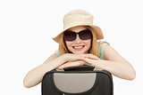 Cheerful woman leaning on a suitcase