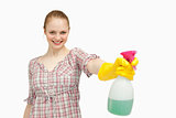 Joyful woman holding a spray bottle while smiling