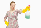 Serious woman holding a spray bottle while looking away