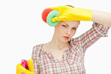 Woman wiping her frown while wearing cleaning gloves