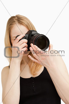 Young woman aiming with a camera