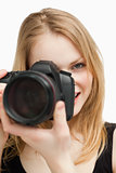 Blonde woman aiming with a camera